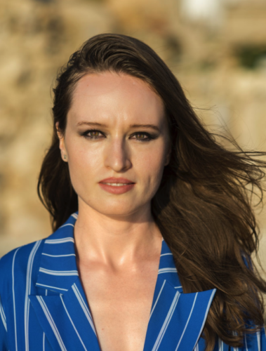 Das Bild zeigt eine Frau (Elena Rykova) mit langen, braunen Haaren. Sie trägt ein blaues Oberteil mit wießen Streifen.